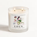 Eden double-wick candle burning in a frosted white glass jar with colorful sweet pea floral label artwork.